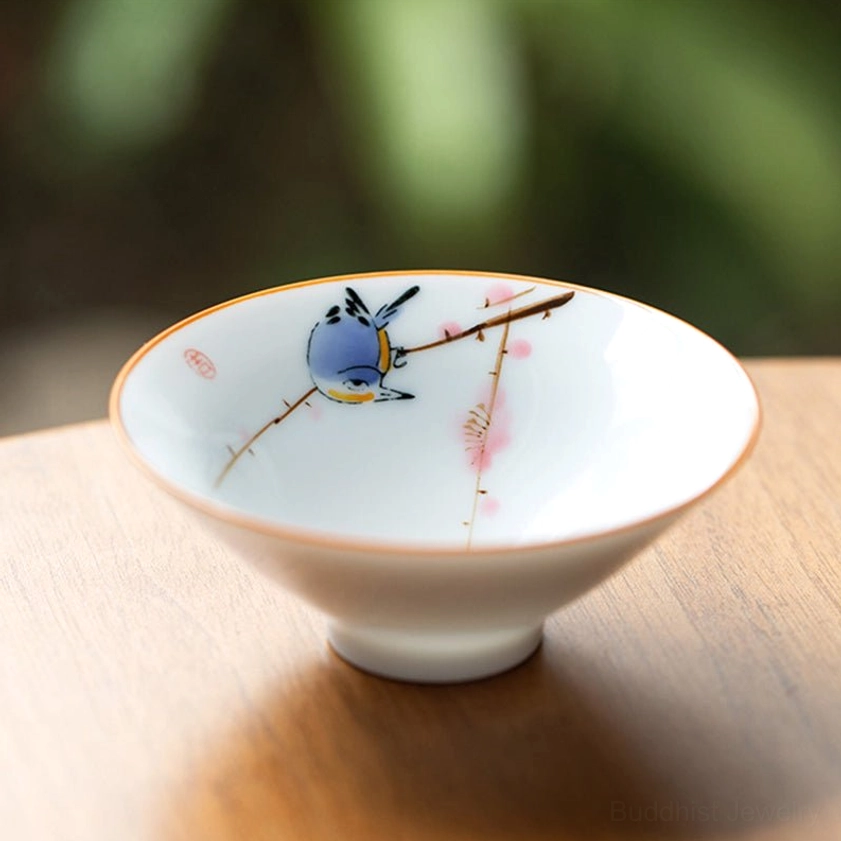 Bird and peach blossom branch porcelain teacup Buddhist bird symbolism hand-painted ceramic