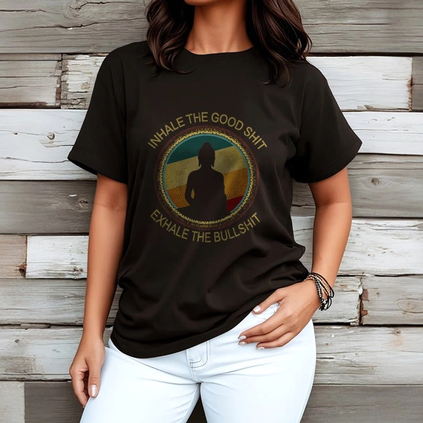 Female model in black mindfulness Buddha cotton t-shirt against wooden wall, front view upper body