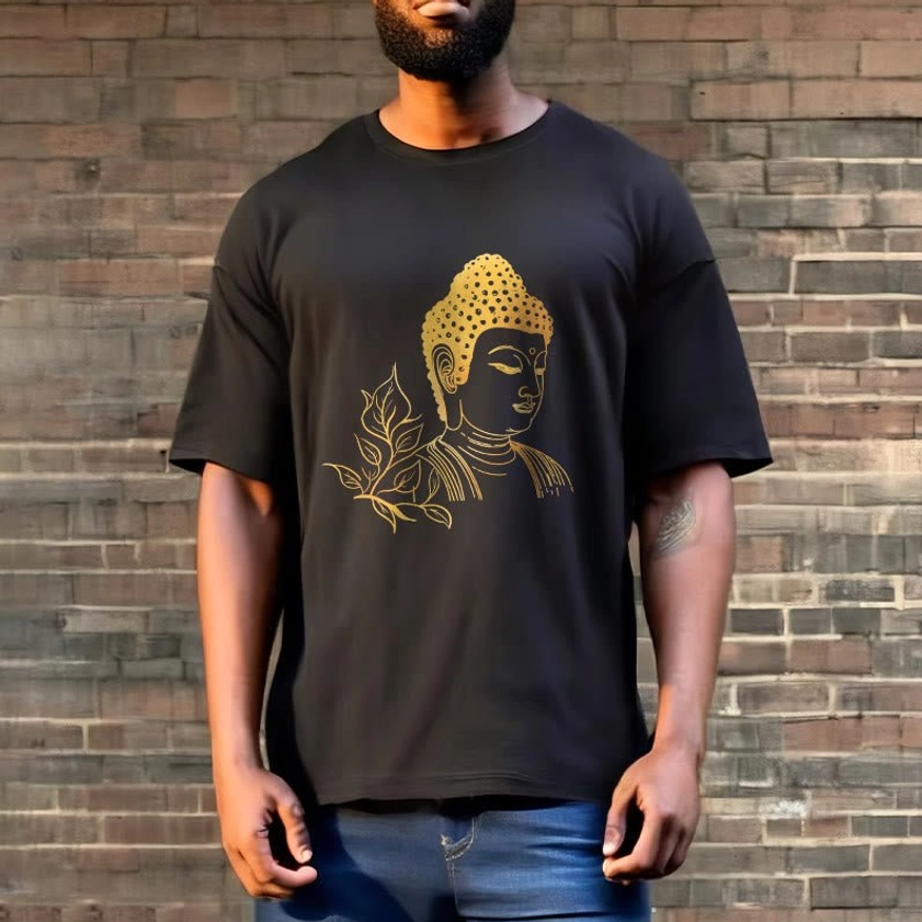Man styling black Buddhist graphic tee with gold leaf and Buddha print outdoors against brick wall