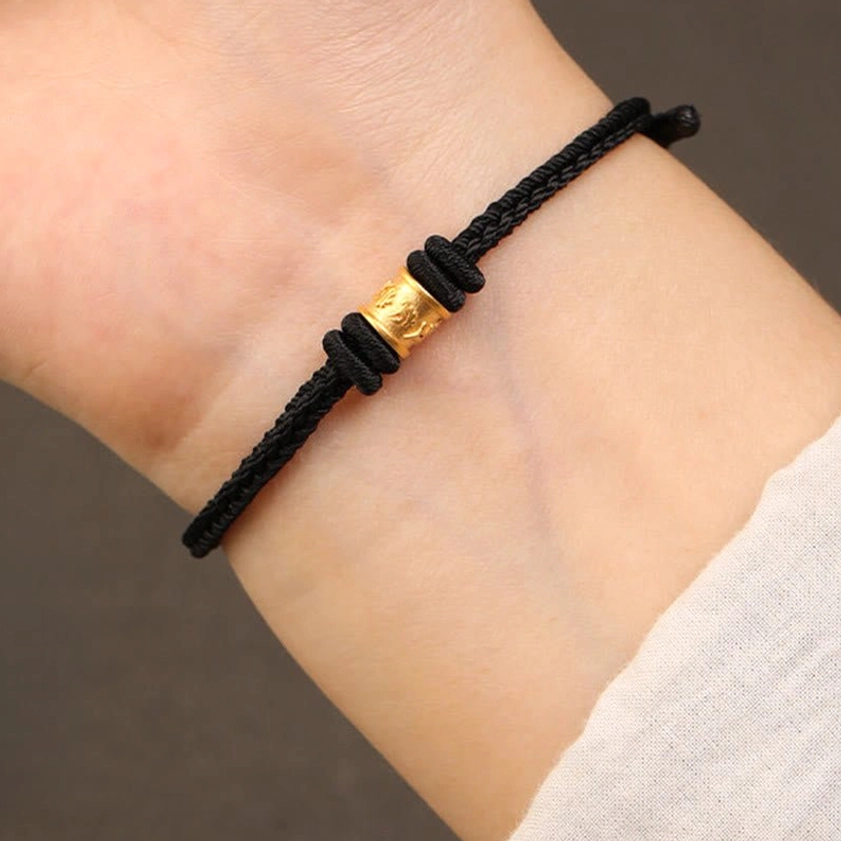 Black braided Buddhist string bracelet with gold Om Mani Padme Hum bead, protective talisman