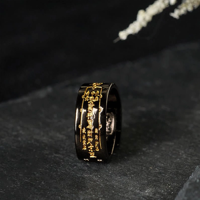 Black polished copper adjustable talisman ring with gold engraved sacred patterns, three-quarter side view showing artisan craftsmanship