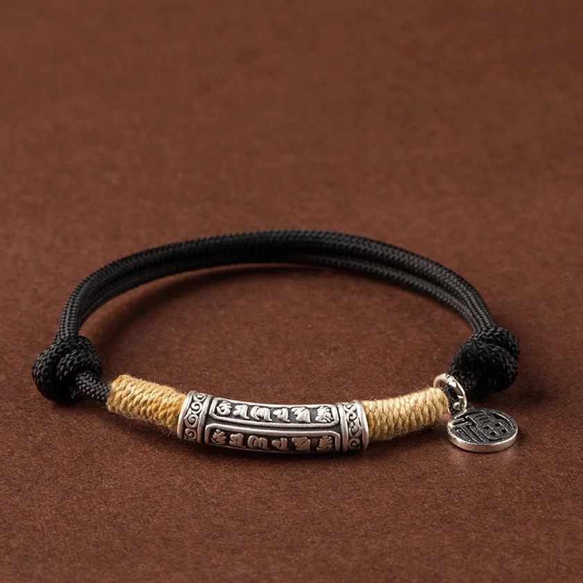 Black cord braided bracelet with embossed six-word mantra silver tube and Fu pendant