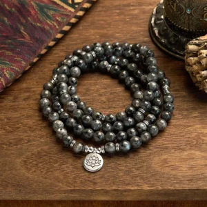 Black glitter stone 108 bead mala bracelet with silver lotus charm, multi-layer design displayed on wooden table