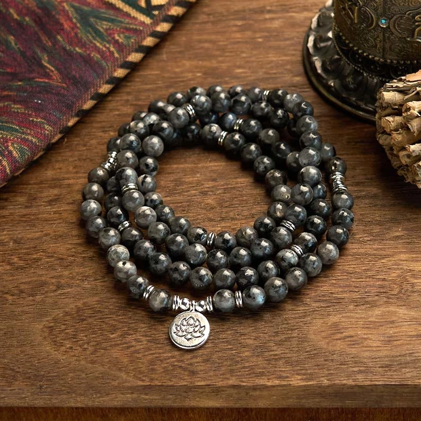 Black glitter stone 108 bead mala bracelet with silver lotus charm, multi-layer design displayed on wooden table