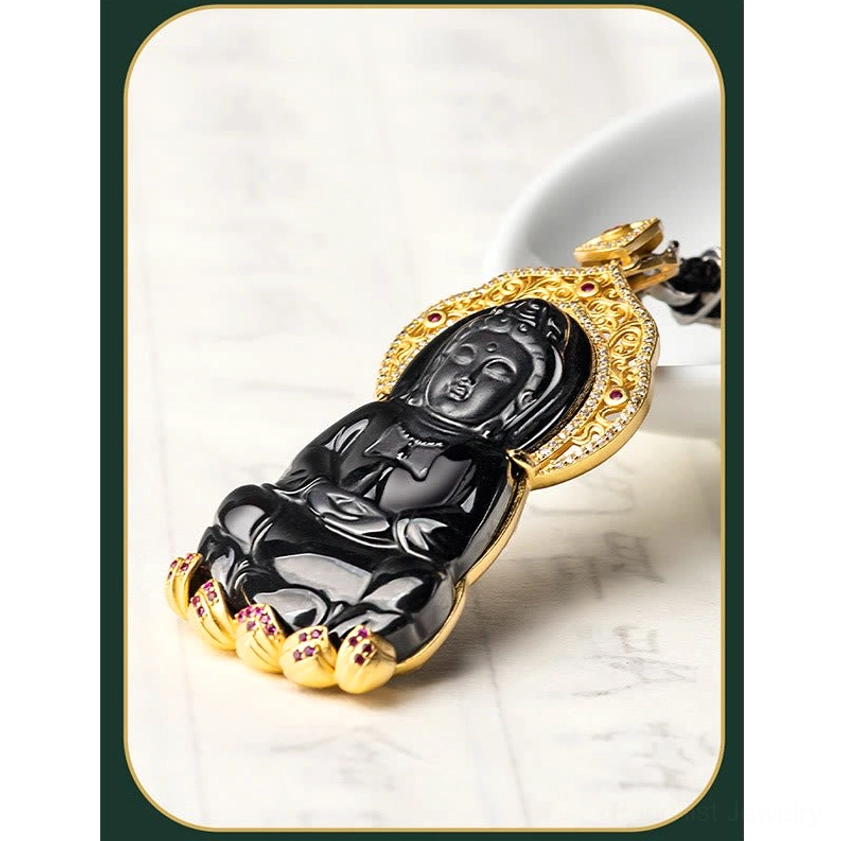 Black jade Avalokitesvara pendant displayed horizontally showing gold-plated frame with red gem accents and detailed hanging mechanism