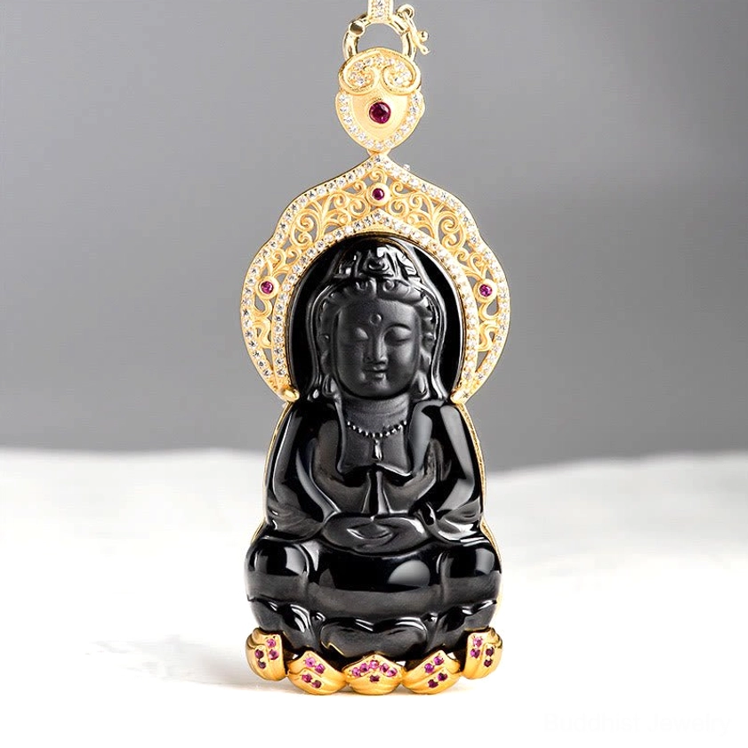 Black jade Avalokitesvara pendant front view showing seated Guanyin with ornate gold-plated filigree frame and red gemstone inlays
