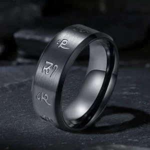 Black Jambhala mantra titanium steel ring with hand-engraved sacred mantras, three-quarter view showing matte black finish and polished inner edge