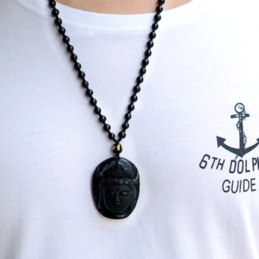 Slim black obsidian Kwan Yin pendant necklace with dainty beaded chain worn on casual white t-shirt, front view