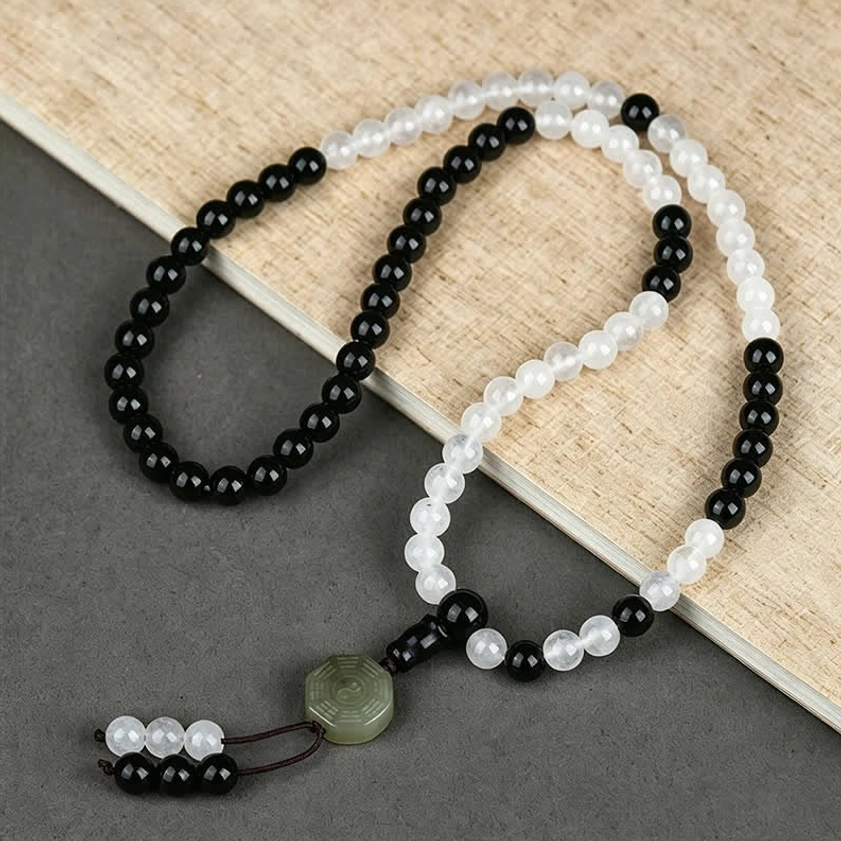 Black Obsidian Bagua protection bracelet with green jade charm and elastic string, flat lay view