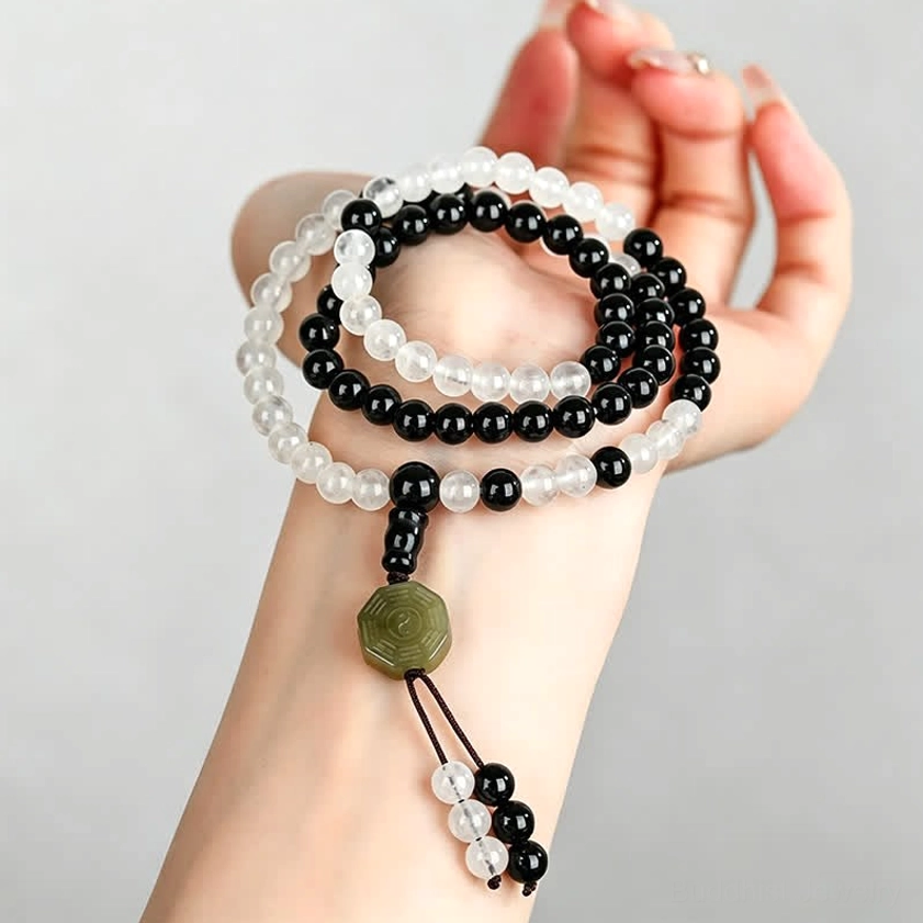 Black Obsidian Bagua bracelets worn on hand - first person view showing multiple strands