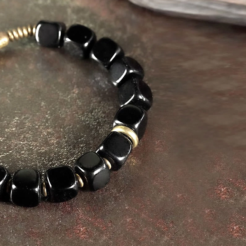 Glossy black obsidian cube beads with gold metal spacers and double brass hardware high angle view
