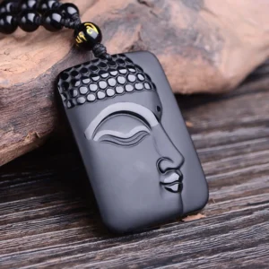 Black Obsidian Buddha Pendant Necklace - Close-up view of carved Buddha face on polished obsidian rectangular pendant with beaded black obsidian chain