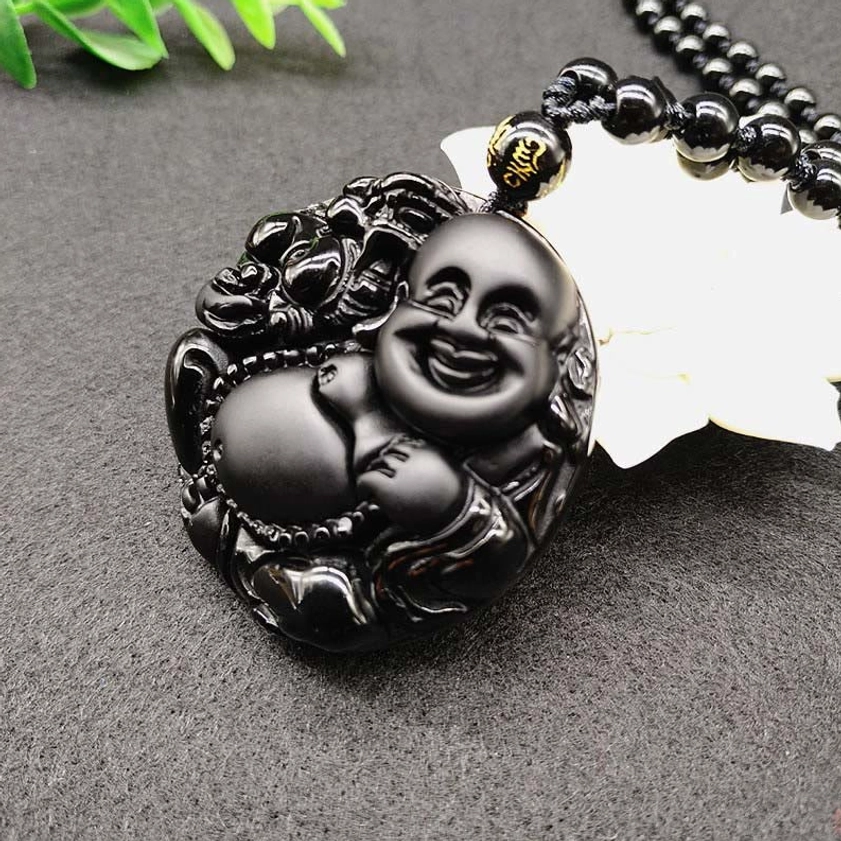 Laughing Buddha Black Obsidian pendant showing polished matte surface and intricate carving details from top-down angle
