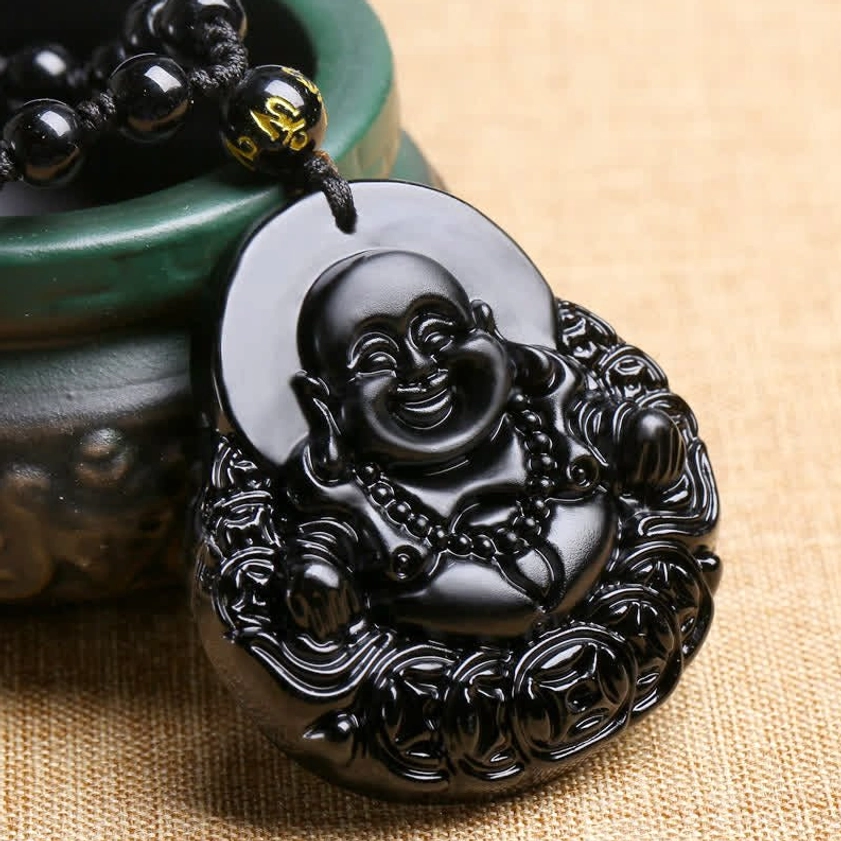 Glossy polished black obsidian laughing Buddha pendant showing detailed three-dimensional carving - side angle view