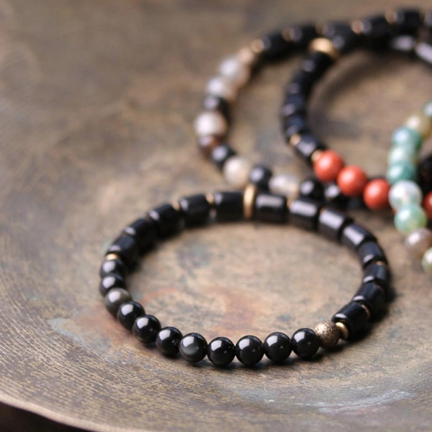 Black obsidian and ebony wood Buddhist bracelet showing protective purification energy for spiritual transformation