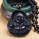 Black obsidian laughing Buddha pendant necklace with carved Buddha and coin design on beaded cord - front view