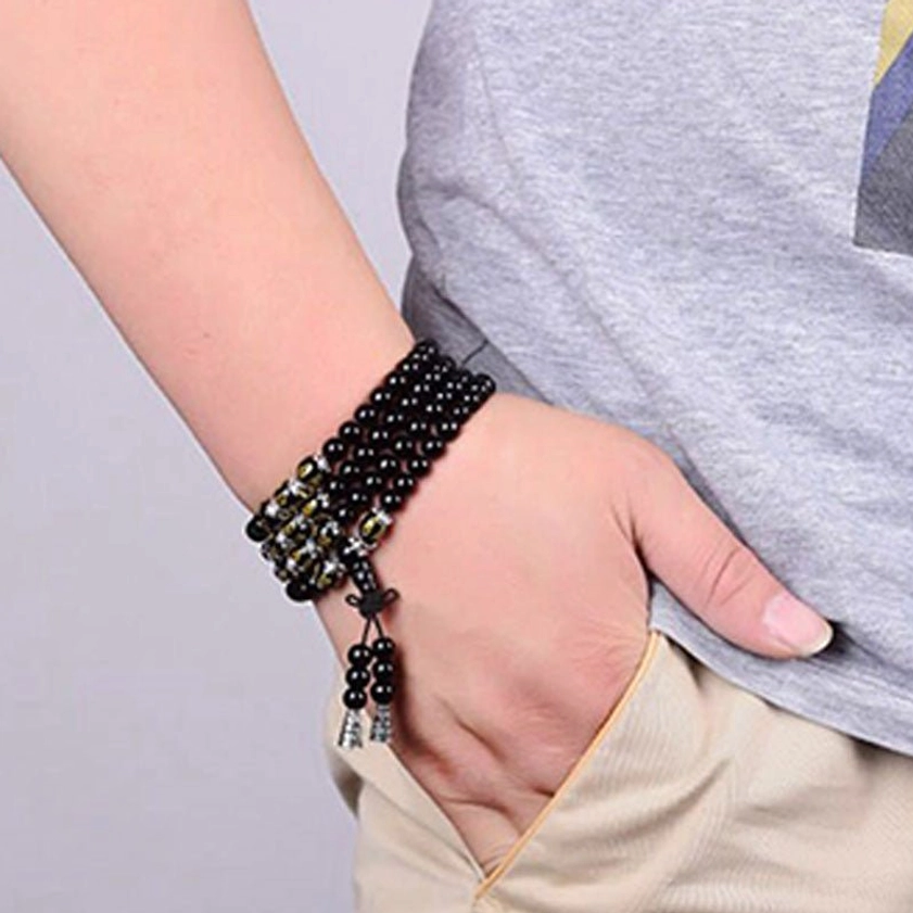 Black Obsidian Om Mani Padme Hum Mala Bracelet wrapped on woman's wrist showing multi-wrap wearable style with tassel pendant