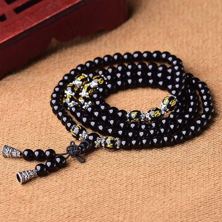 Coiled Black Obsidian Om Mani Padme Hum Mala Bracelet with smooth black beads, golden engraved accents and silver tassel charms