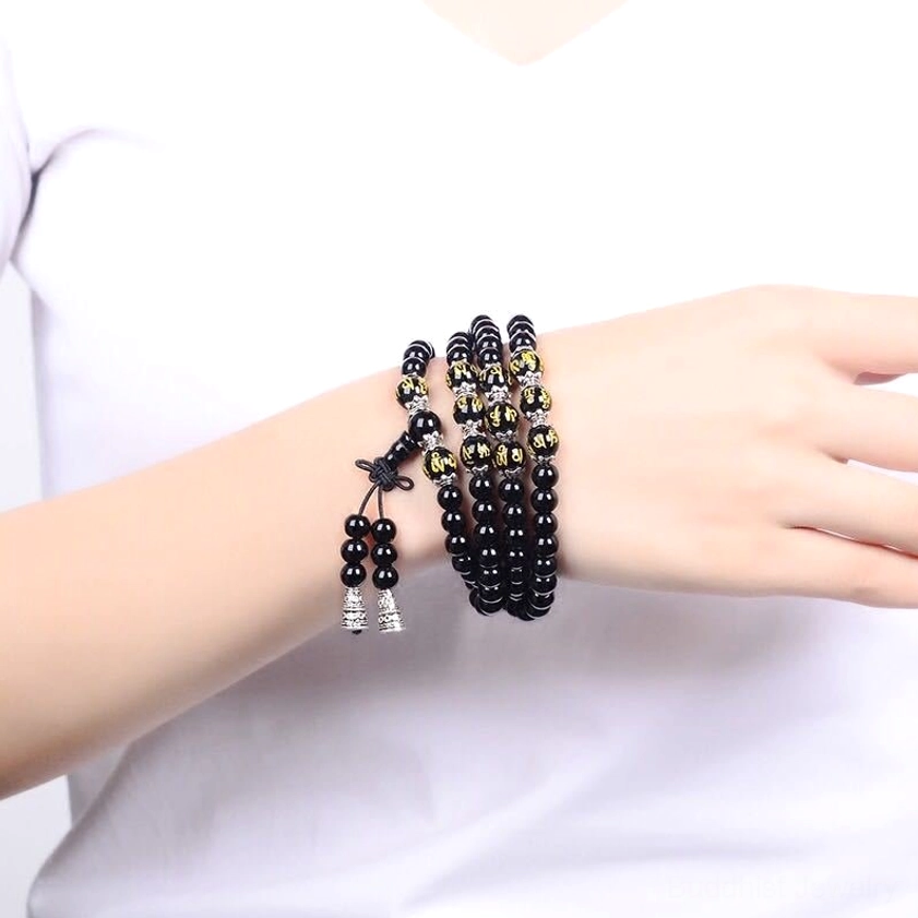 Black Obsidian Om Mani Padme Hum Mala Bracelet double-wrapped on woman's wrist with layered beaded design and silver metal accents