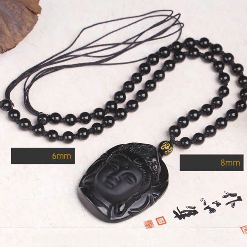 Black obsidian Avalokitesvara pendant necklace displaying 6mm and 8mm beaded chain options on textured desktop with calligraphy stamps