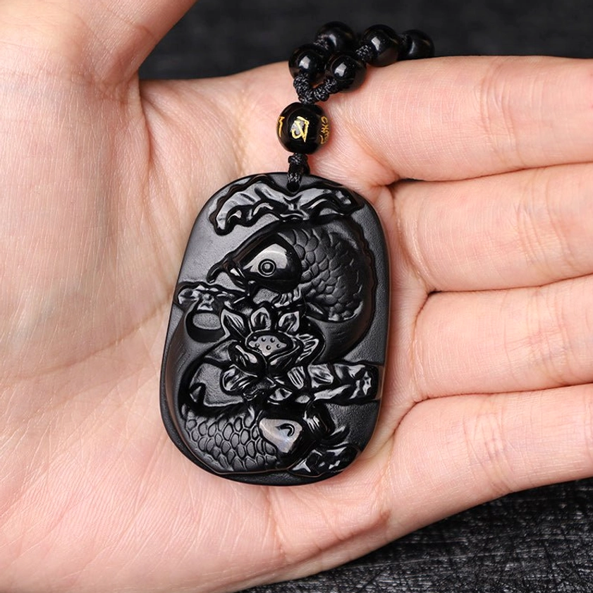 Black Obsidian Koi Fish Lotus Pendant Necklace - held in palm showing scale and smooth polished black stone finish