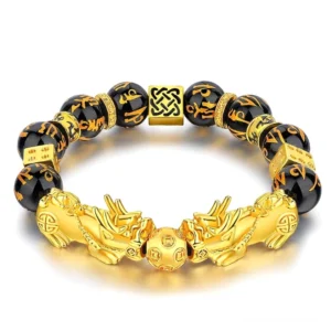 Black obsidian double Pixiu wealth bracelet with engraved Om Mani Padme Hum Sanskrit beads and golden charms on white background - front view