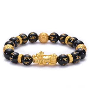Black obsidian Buddhist bracelet with engraved Om Mani Padme Hum mantra beads and gold PiXiu charm, top-down flat lay view