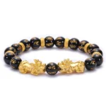 Black Obsidian Pixiu Om Mani Padme Hum Buddhist bracelet overhead view with golden charms and engraved beads