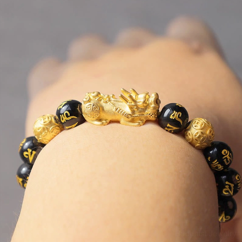 Black obsidian beads with gold Sanskrit engravings detail view of authentic Buddhist wealth bracelet craftsmanship