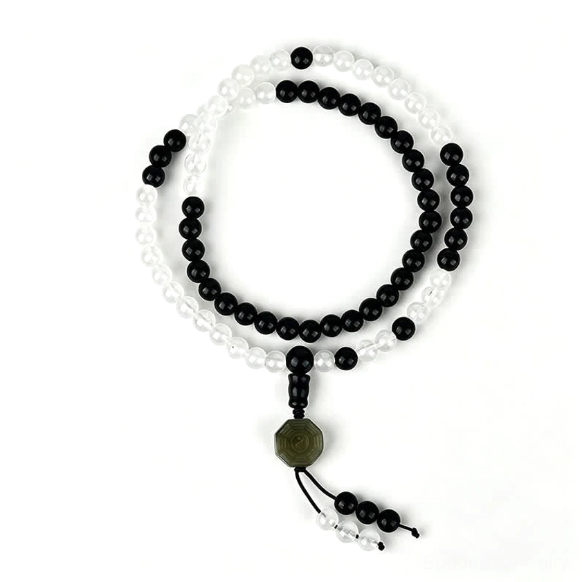 Single strand Black Obsidian Yin-Yang bracelet with green jade Bagua pendant on gray background
