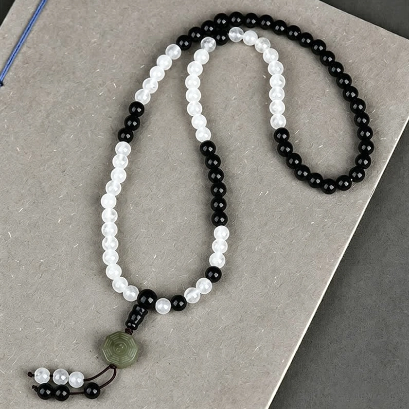 Handmade Black Obsidian and white crystal beaded bracelet with Yin-Yang Bagua pendant on gray background