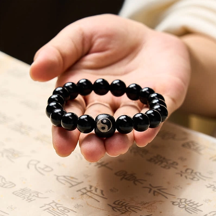 Black obsidian yin yang balance bracelet close up detail shot of engraved centerpiece bead