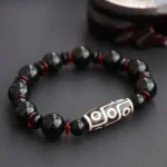 Black Onyx Nine-Eye Dzi Bead Bracelet front view with white hand-painted dzi bead and red spacers