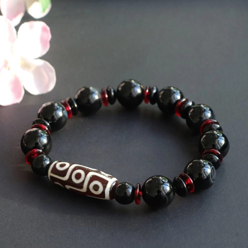 Black Onyx Dzi Bead Bracelet flat lay with polished beads and decorative background