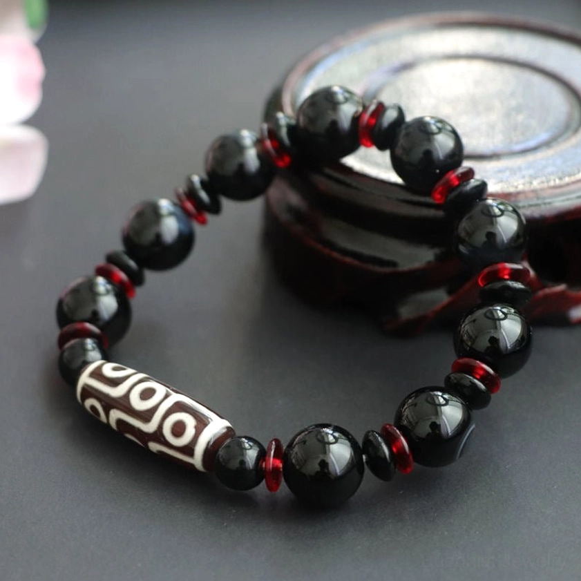 Black Onyx Dzi Bead Bracelet side angle showing polished beads and white patterned dzi