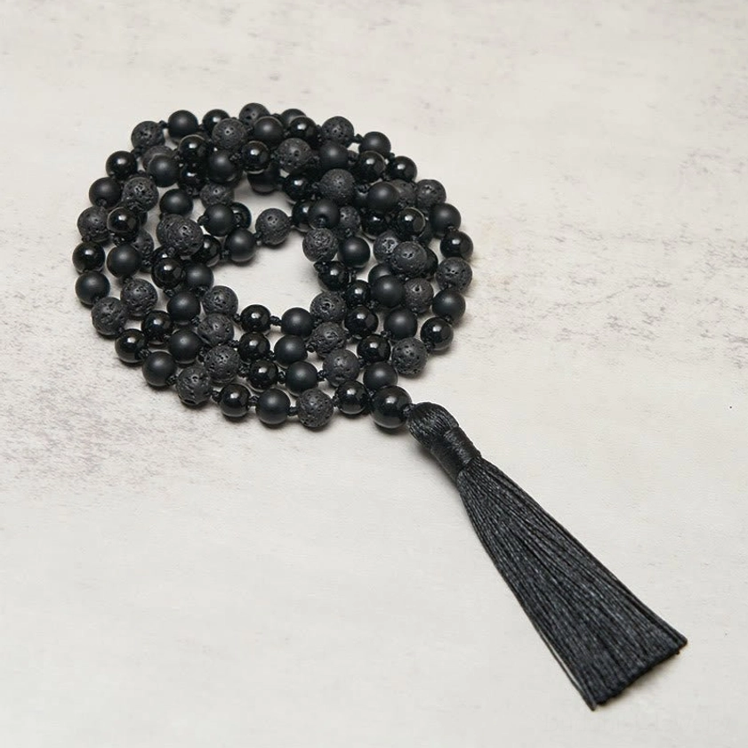 Black Onyx and Lava Rock 108 bead mala necklace with tassel, top-down view showing mixed matte and polished gemstone beads
