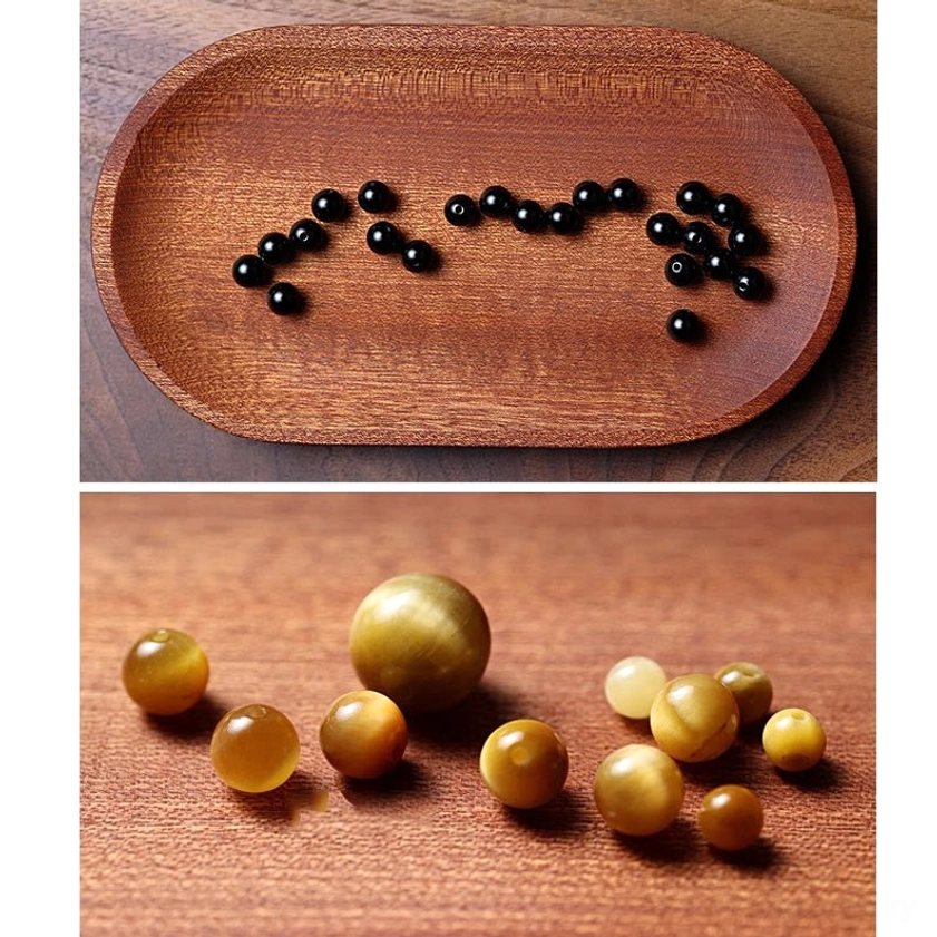 Loose polished black onyx round beads 6mm and 8mm sizes on wooden tray