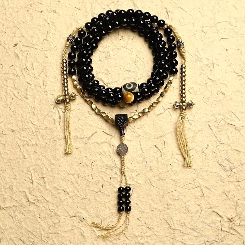 108 black onyx mala beads bracelet with three-eyed dzi bead flat lay display showing complete handcrafted set