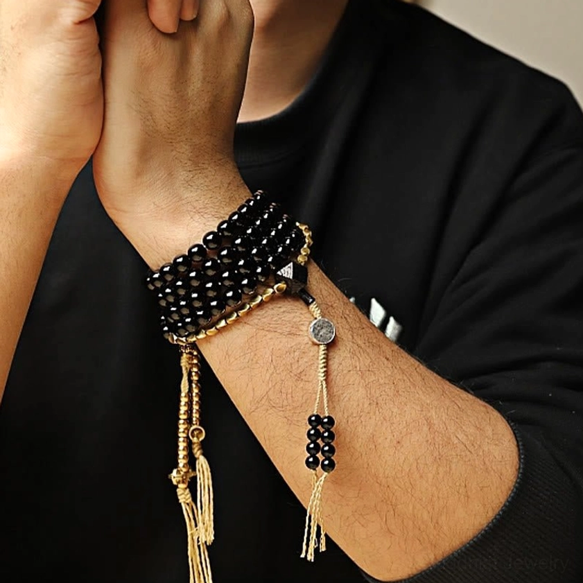 Black onyx mala beads with three-eyed dzi bead showing handcrafted natural stone quality