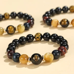 Black onyx tiger eye Buddhist bracelet with Om Mani Padme Hum mantra bead and Chinese zodiac natal Buddha charm, multi-angle overhead view