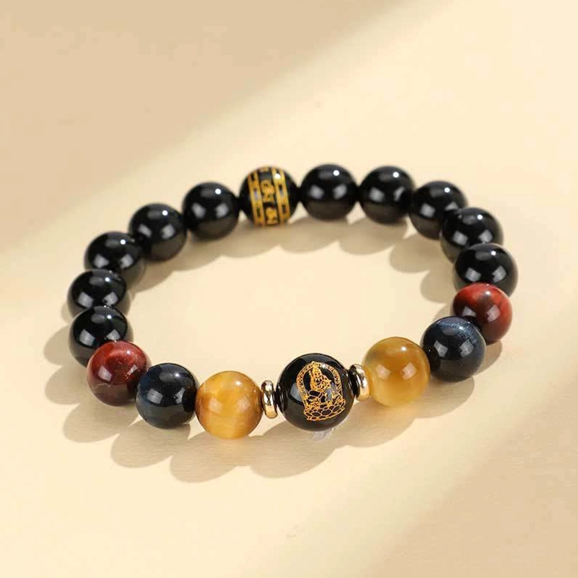 Polished black onyx and tiger eye round gemstone beads in natural light showing color gradations