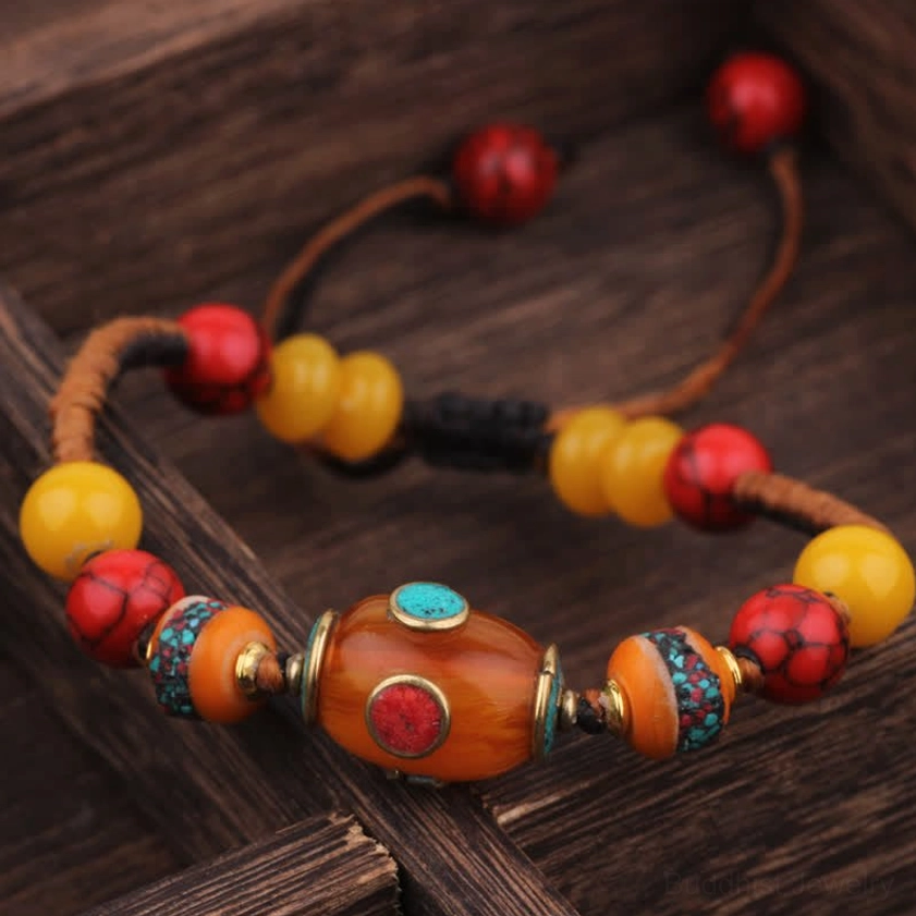 Black orange rope Buddhist bracelet with amber central bead and warm colored beads, handcrafted adjustable cord