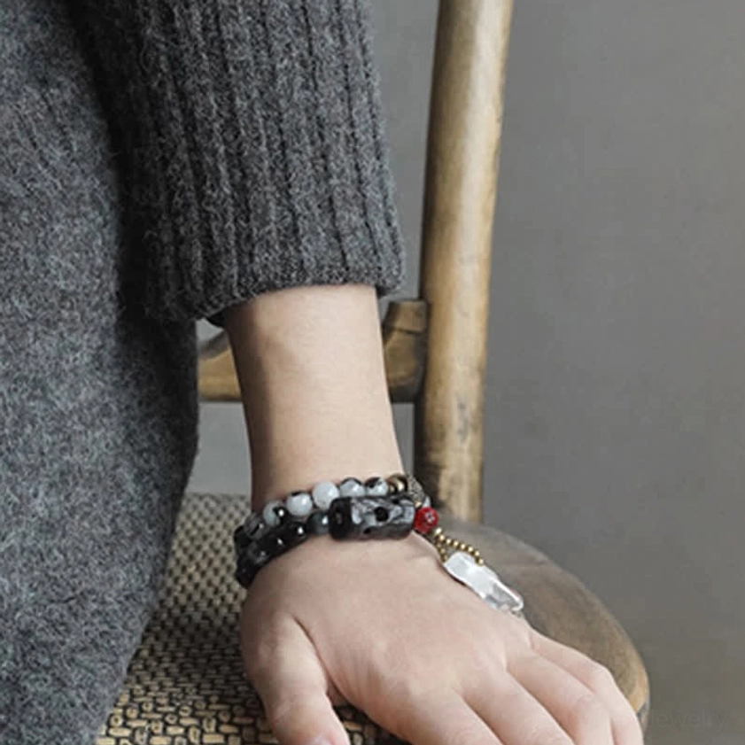 Man wearing Black Rutilated Quartz couple bracelet set on both wrists with knitted sweater background