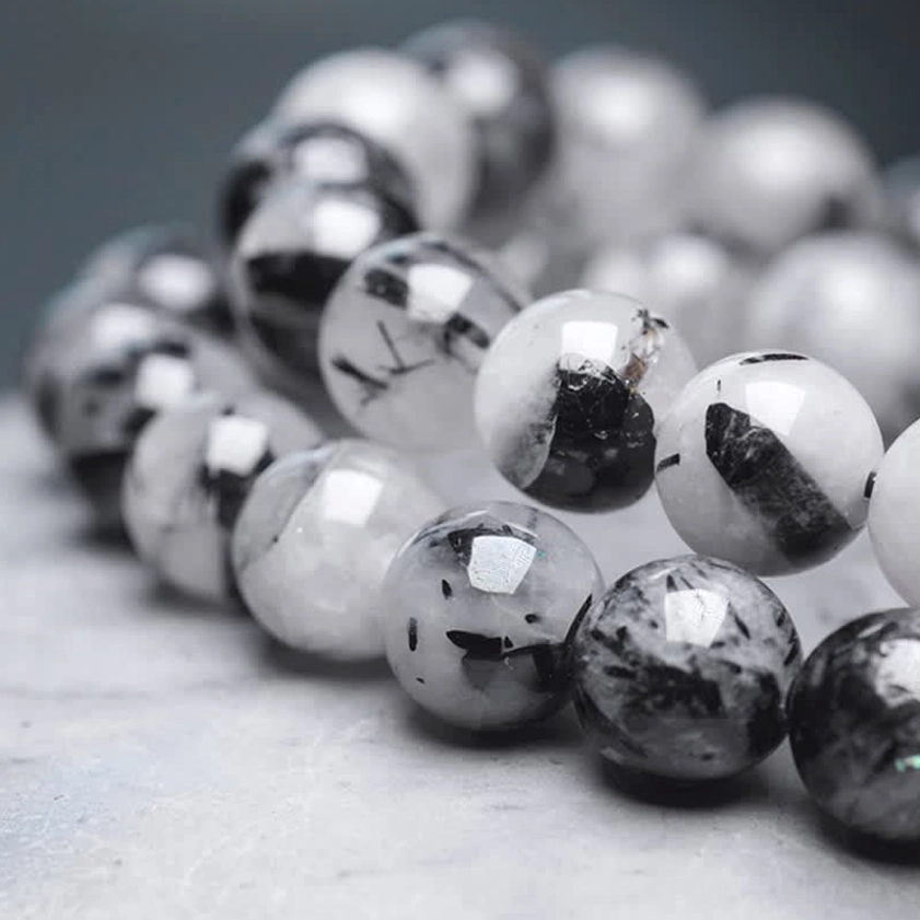 Macro detail of Black Rutilated Quartz beads showing golden needles and natural texture