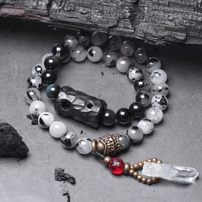 Black Rutilated Quartz White Crystal Buddhist couple bracelet flat lay top view with ebony wood charm