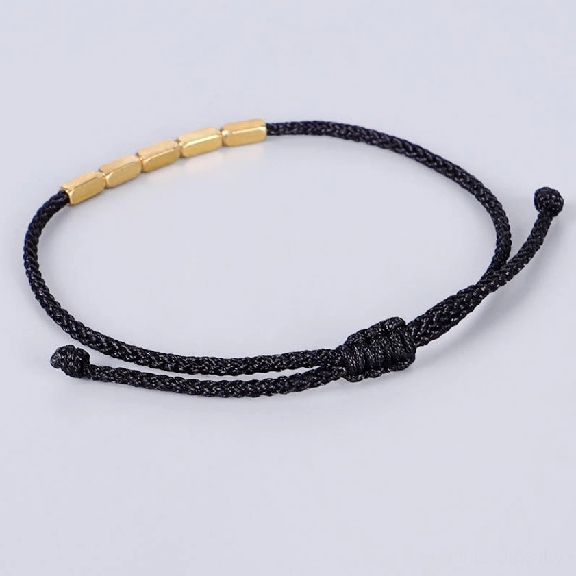 Black woven nylon cord Buddhist bracelet with gold copper beads and central pull-knot design