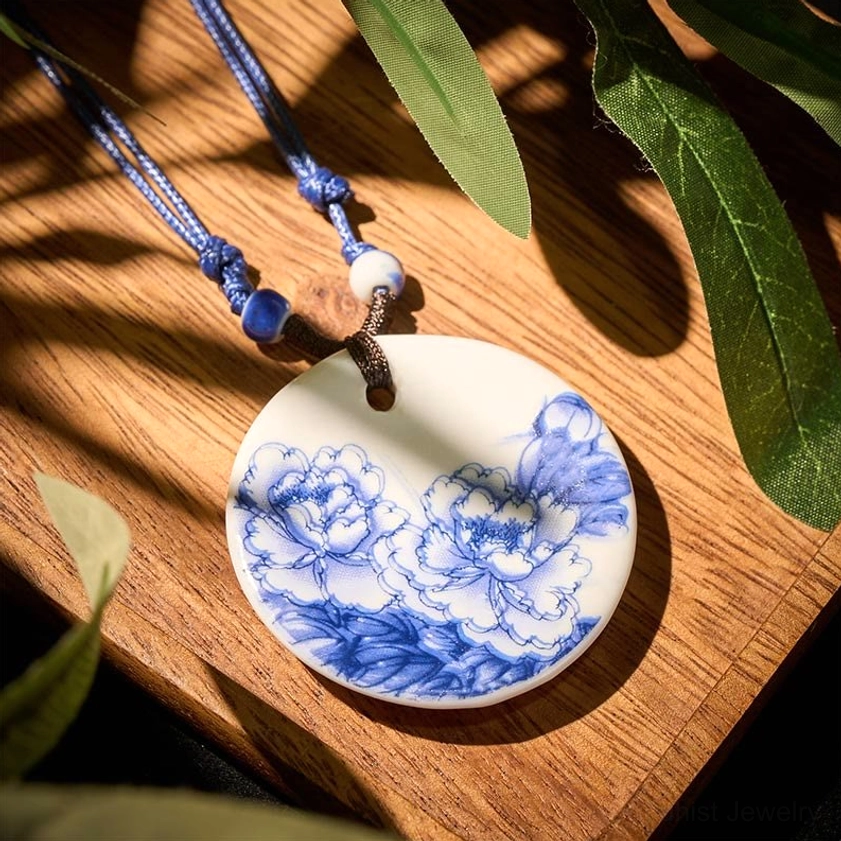 Blooming peonies ceramic pendant necklace overhead flat lay view on wooden surface