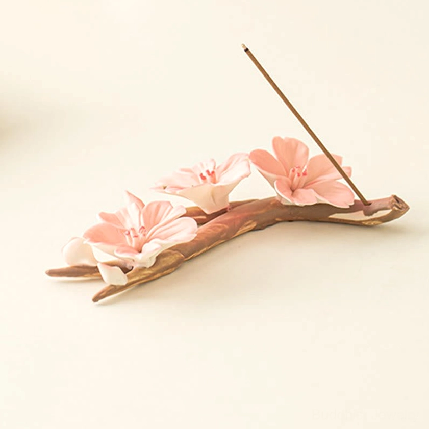 Cherry blossom incense burner with pale pink ceramic flowers and warm brown branches, side flat lay profile view