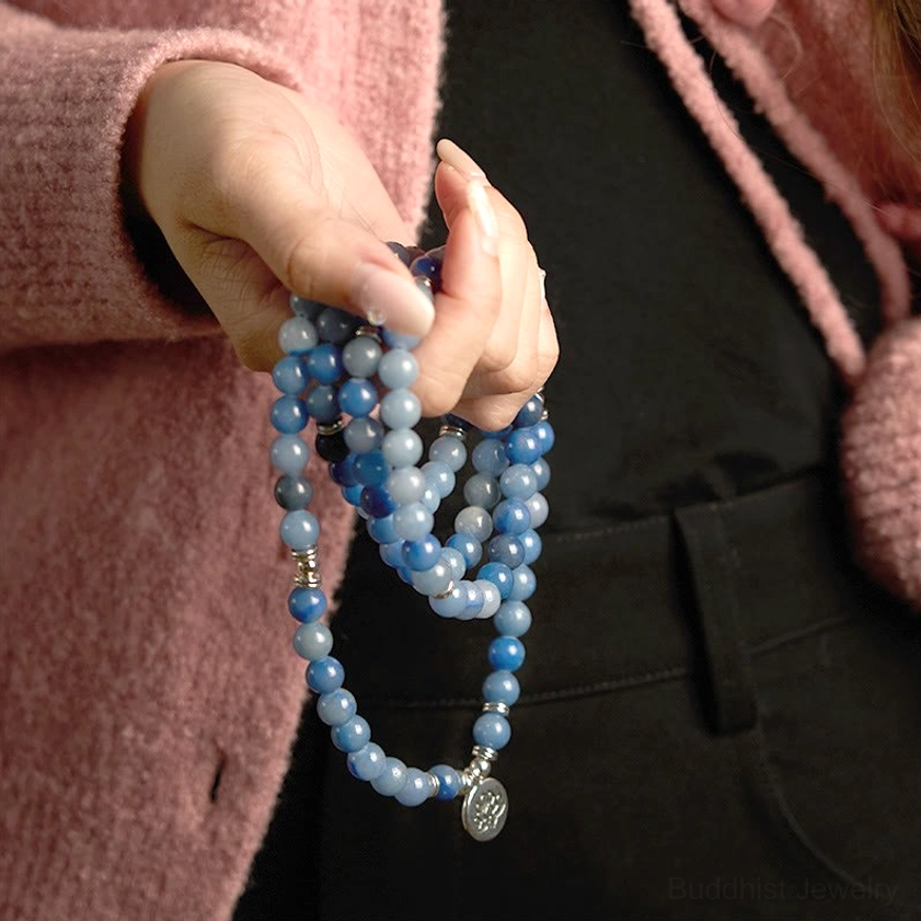 Handmade blue aventurine 108 mala beads close-up folded in hands showing bead texture