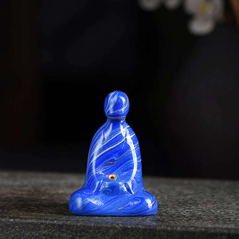 Single blue marbled ebony wood Buddha incense holder on studio dark background